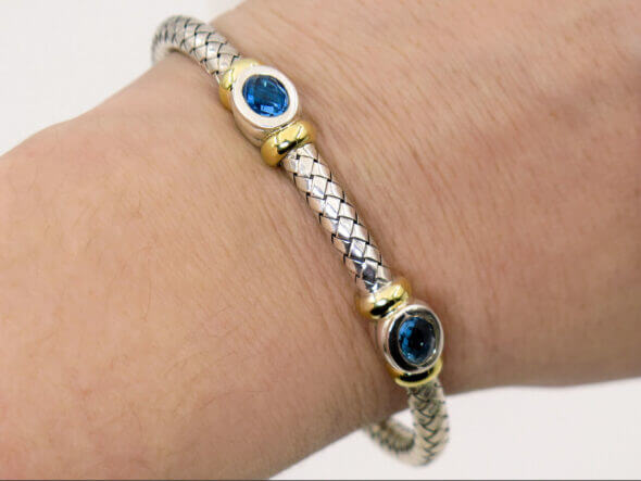 Silver and 18 Karat Yellow Gold Weave Bracelet with Bezel Set Topaz on a view