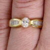 14 Karat Yellow Gold Oval and Baguette Diamond Ring on a hand