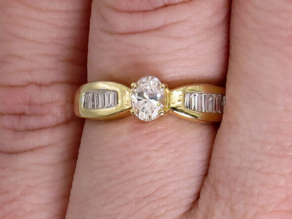 14 Karat Yellow Gold Oval and Baguette Diamond Ring on a hand