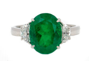 Platinum 4.07 carat oval Colombian Emerald with Half Moon Shaped Diamond Side Stones